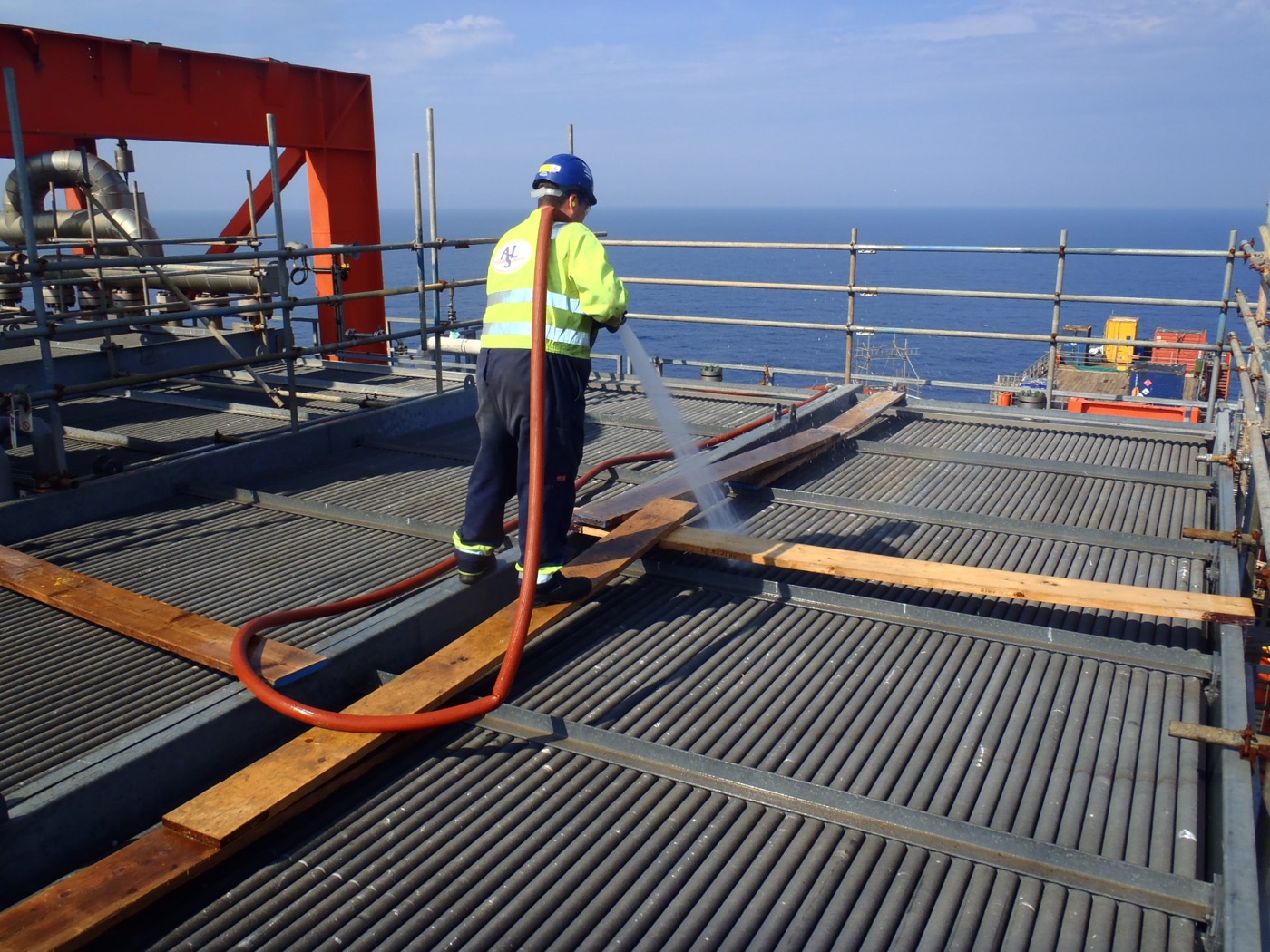 Operator washing fin fan bundles from an elevated work platform
